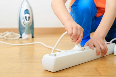 child plugging in an iron